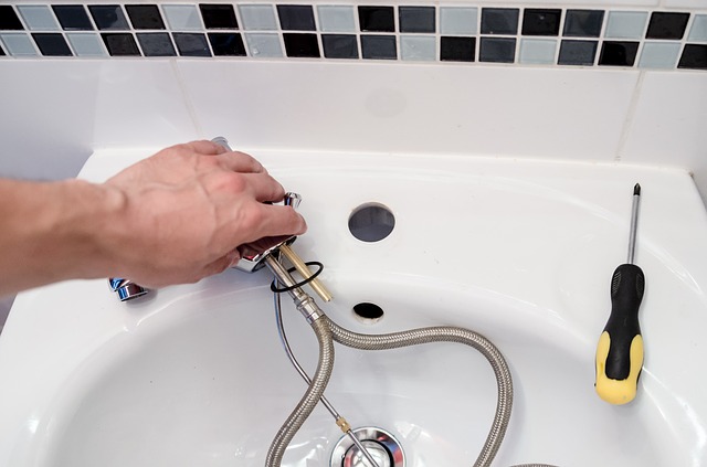 A plumber replacing a faucet for the bathroom sink.