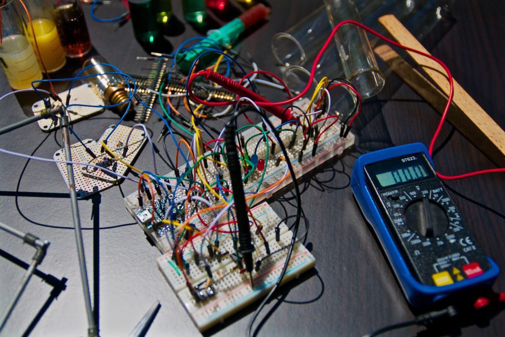 Electronic circuit boards lay near a tester.