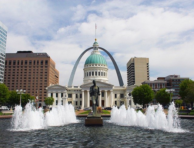 The Missouri Gateway Arch in Kiener Plaza, with a statue and a fountain in the foreground. 