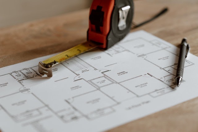 Home floor plan and measuring tape in preparation for a home improvement or remodeling project.