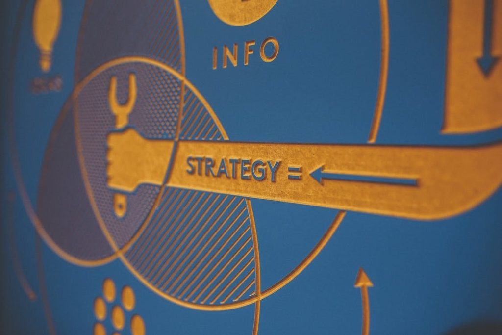 An engraved graphic that depicts the words “strategy” and “info.” 