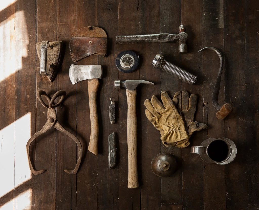 A display of tools on a wooden workbench.