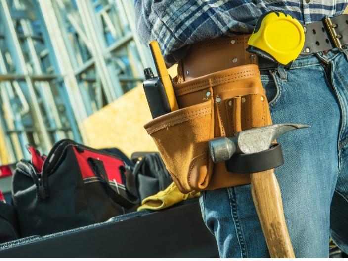 A Handyman wearing a tool belt standing at construction site 