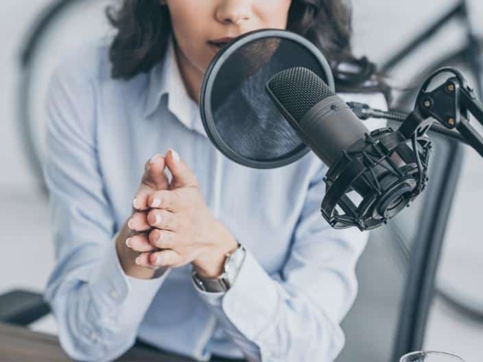 woman in front of podcast microphone