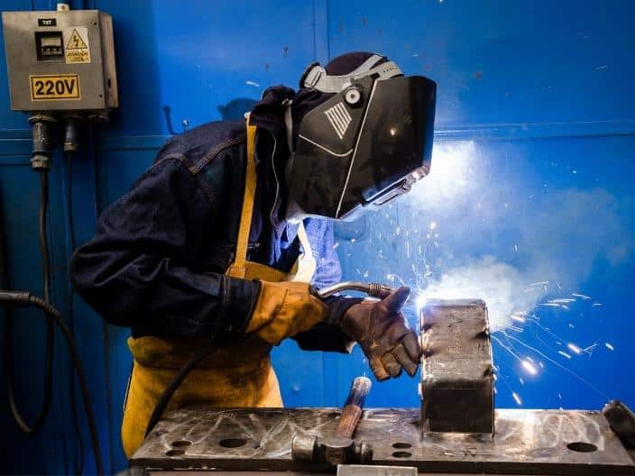 welder welding with gloves and helmet