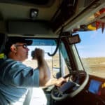 Male driver hands holding radio and steering wheel truck dashboard with driver